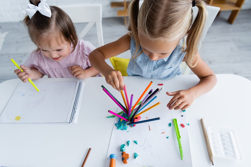 Little girls are coloring and drawing in a daycare that provides a safe and healthy environment